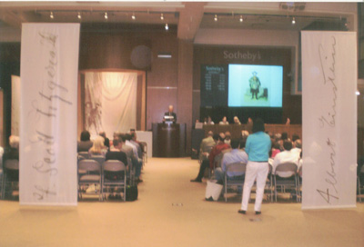 Sotheby's sign flanked by F.Scott Fitzgerald's signature(left) and Albert Einstein's signature (right).