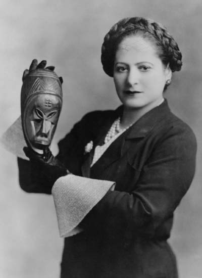 Helena Rubinstein with African mask, c. 1935. Helena Rubinstein Foundation archive, Fashion Institute of Technology, State University of New York, Special Collections.  Photograph by George Maillard Kesslere