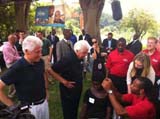  NFL Player Larry Fitzgerald helps fit a patient with a hearing device during the Foundations recent hearing mission in Uganda, as President Bill Clinton, Chelsea Clinton and Starkey Hearing Foundation Founde  Bill Austin look onr