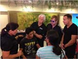 Sir Elton John, David Furnish and Starkey Hearing Foundation founders Bill and Tani Austin help a young man hear during the Foundations mission in Manila, Philippines on December 8