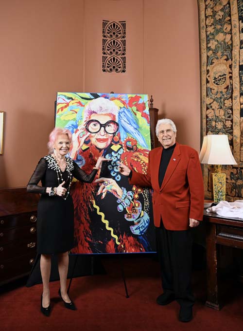 Jane Pontarelli  and Joe Pontarelli with portrait of Iris Apfel