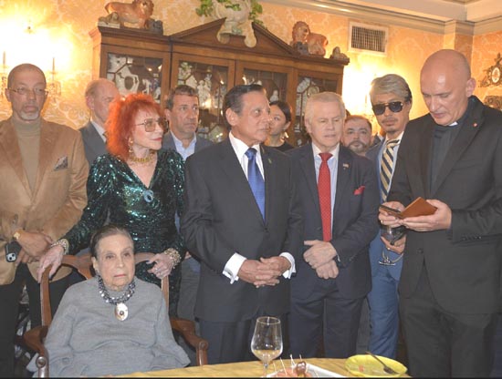 Reverend Canon Grzegorz Stasiak giving a blessing, Guiseppe Signorrini, Tomaczek Bednarek, Chuck Huller, Dr. Judy Kuriansky, and Gloria Starr Kins (seated)